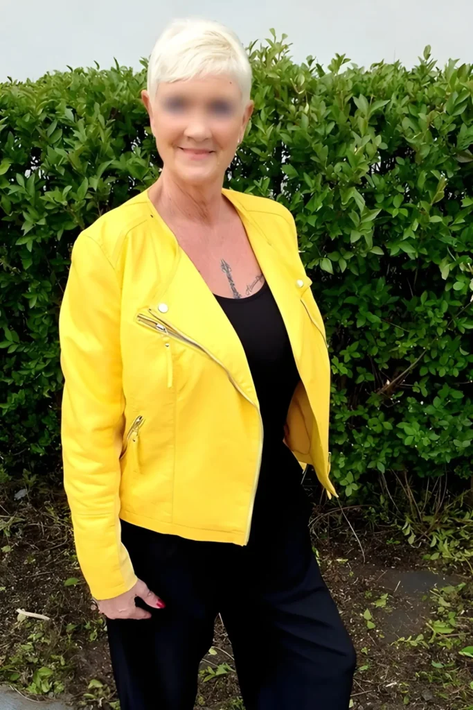Chantal bekleidet mit einer leuchtend gelben Jacke über schwarzer Kleidung.