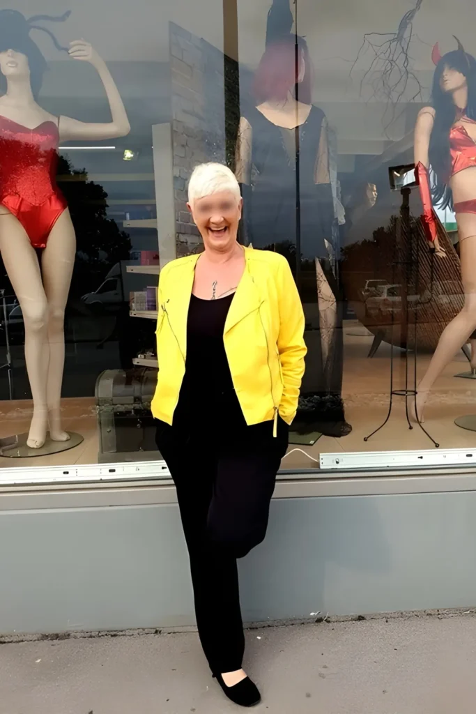 Chantal mit kurzen weißen Haaren, die eine gelbe Jacke
