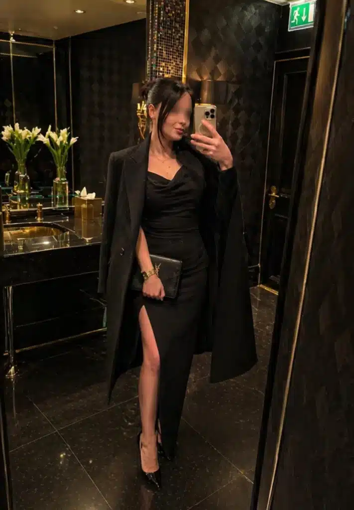 Lilly in a black evening gown in front of a mirror