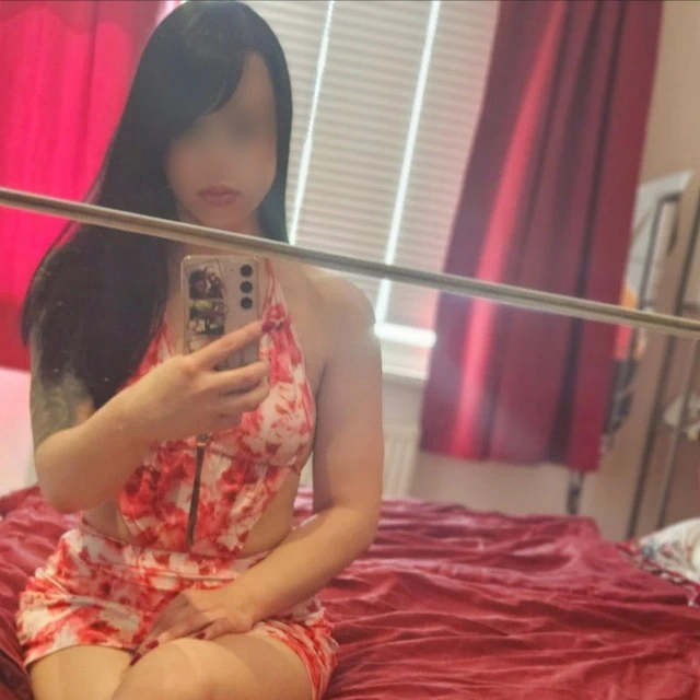 Lilly, mit langen dunklen Haaren und einem rot-weiß gemusterten Kleid.