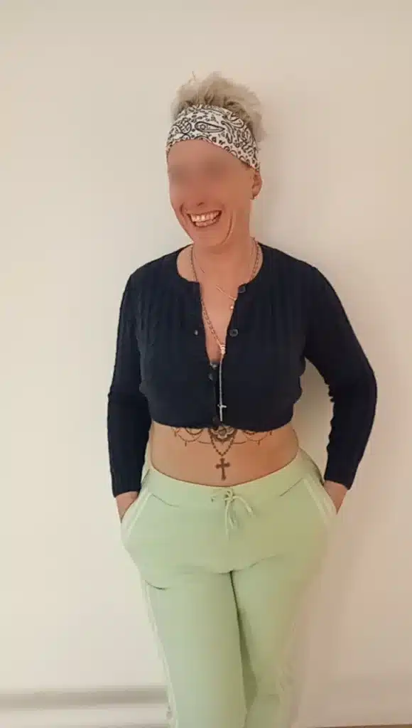 Livia is dressed in athletic clothes and is laughing in a relaxed way.