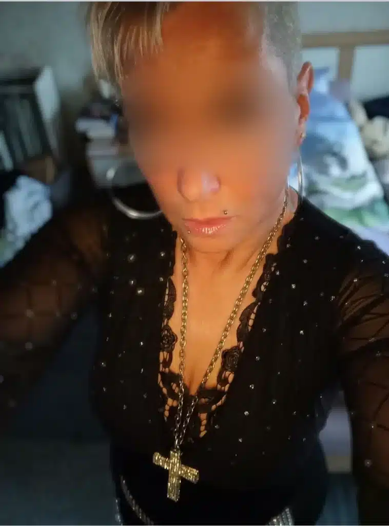 Vienna escort Lady Livia, with short hair, is wearing a black top with mesh sleeves