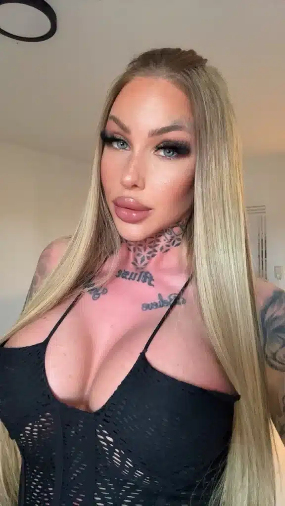 Vanessa, wearing makeup and showing her tattoos, poses for the camera