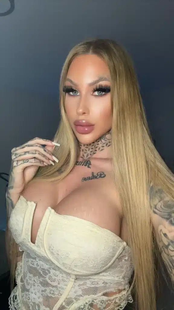 Vanessa, who has tattoos on her neck and chest, is wearing a cream-colored lace top.