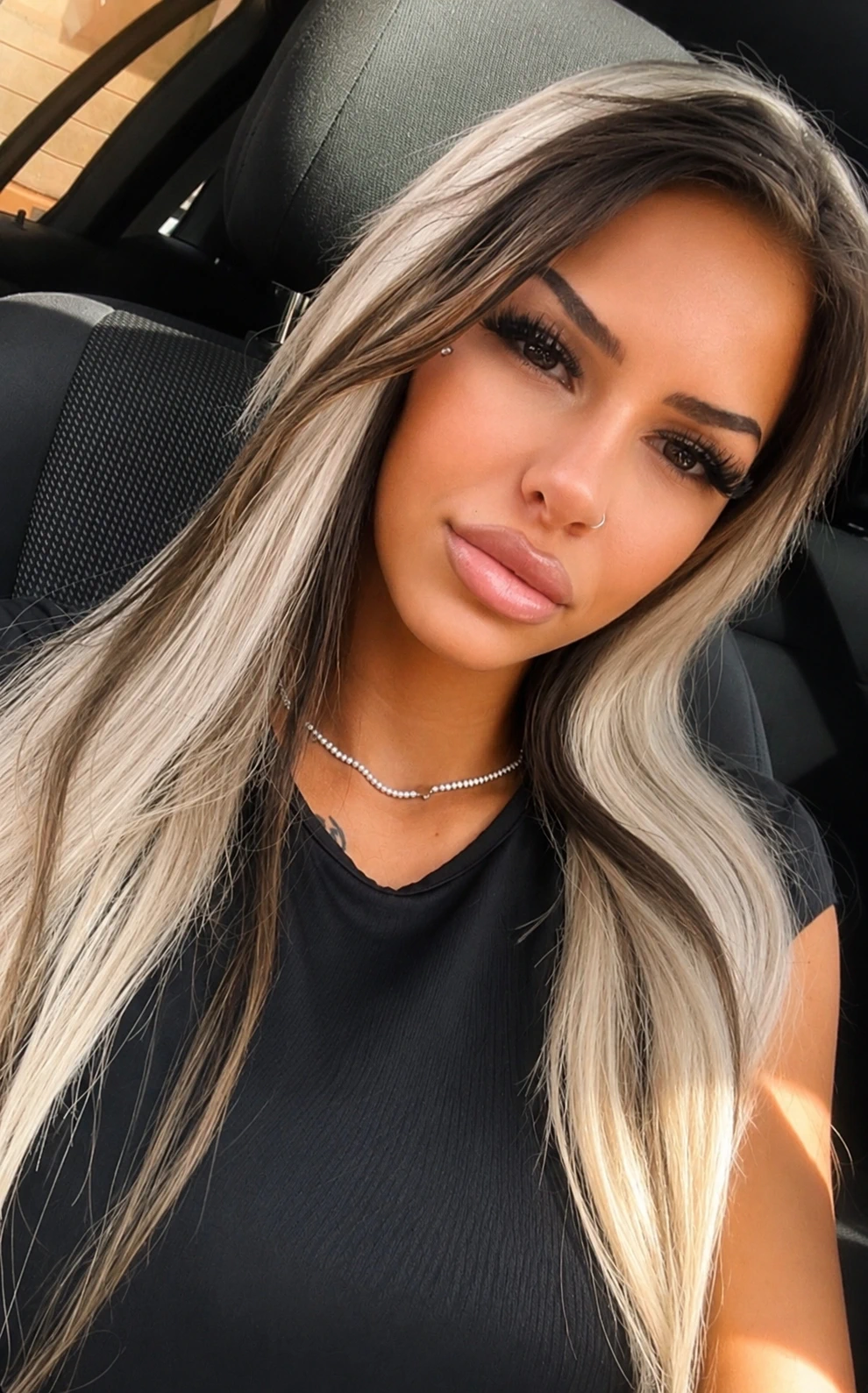 Xenia mit blonden und braunen Haaren sitzt in einem Auto.